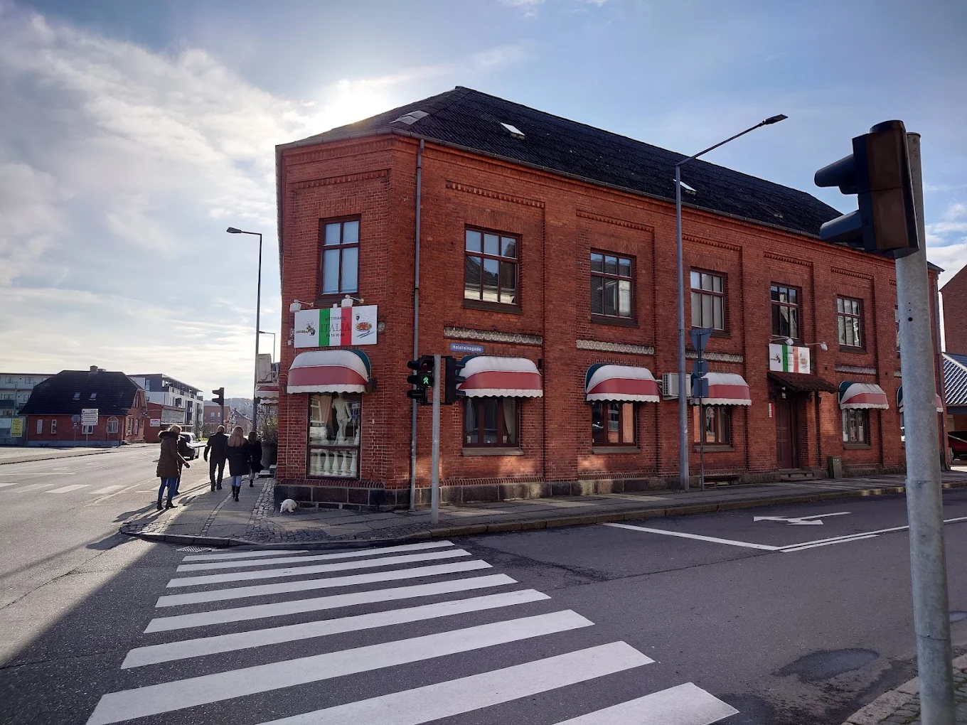 Ristorante Italias røde murstensbygning med rød-hvide markiser på hjørnet af Holsteinsgade i Odder